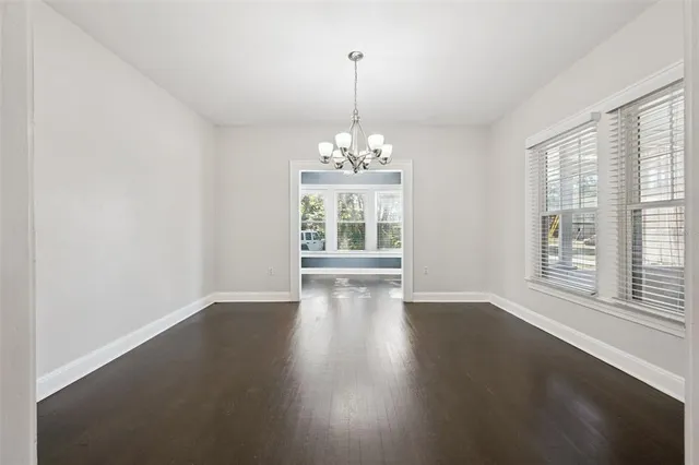 a view of a room with wooden floor chandeliers and a window