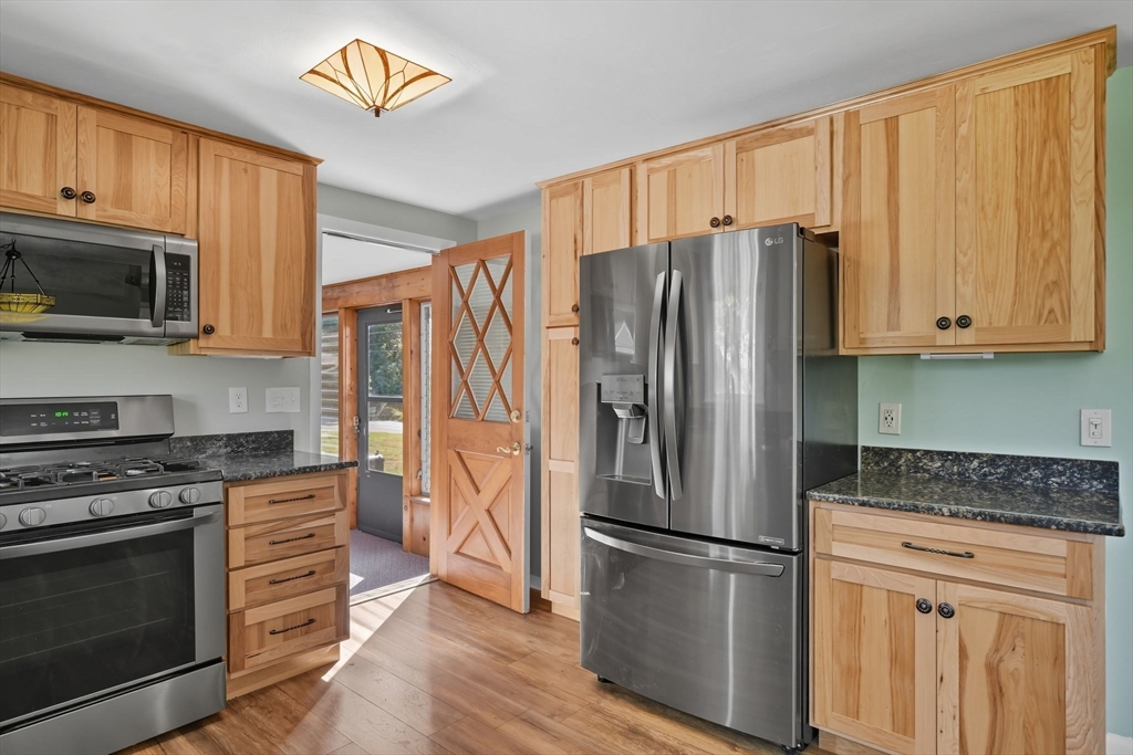 22 Colorado Street Springfield, MA 01118 - Photo 7 of 39 a kitchen with granite countertop a refrigerator stove and microwave