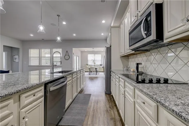 a large kitchen with stainless steel appliances granite countertop a lot of counter space