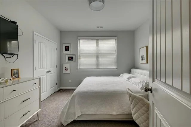 a bedroom with a bed a window and dresser