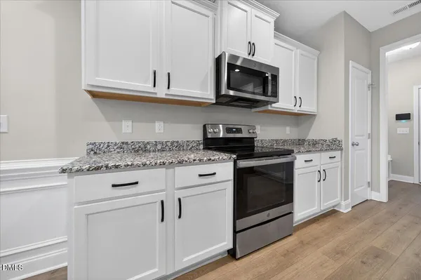 a kitchen with a refrigerator and a stove top oven