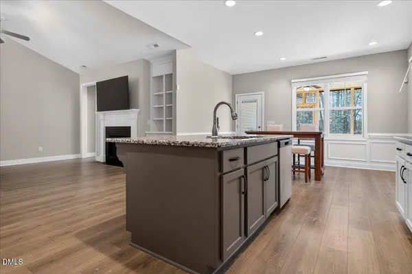 a kitchen with granite countertop a sink stove and cabinets