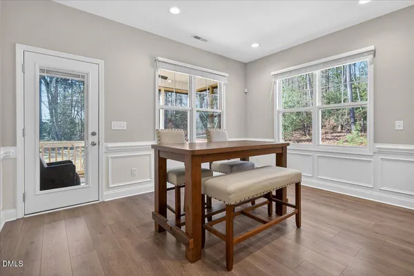 a kitchen with kitchen island granite countertop wooden floors appliances and white cabinets