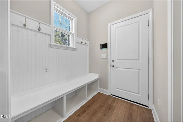 a view of a hallway with wooden floor and a living room