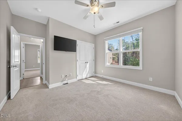 a spacious bedroom with a bed and window