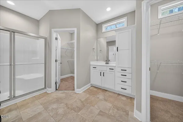 a spacious bathroom with a shower sink and mirror