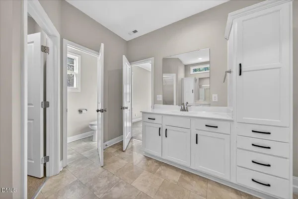 a bathroom with a sink vanity and mirror