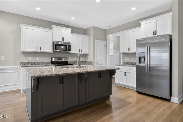 a kitchen with stainless steel appliances granite countertop a refrigerator stove microwave and sink
