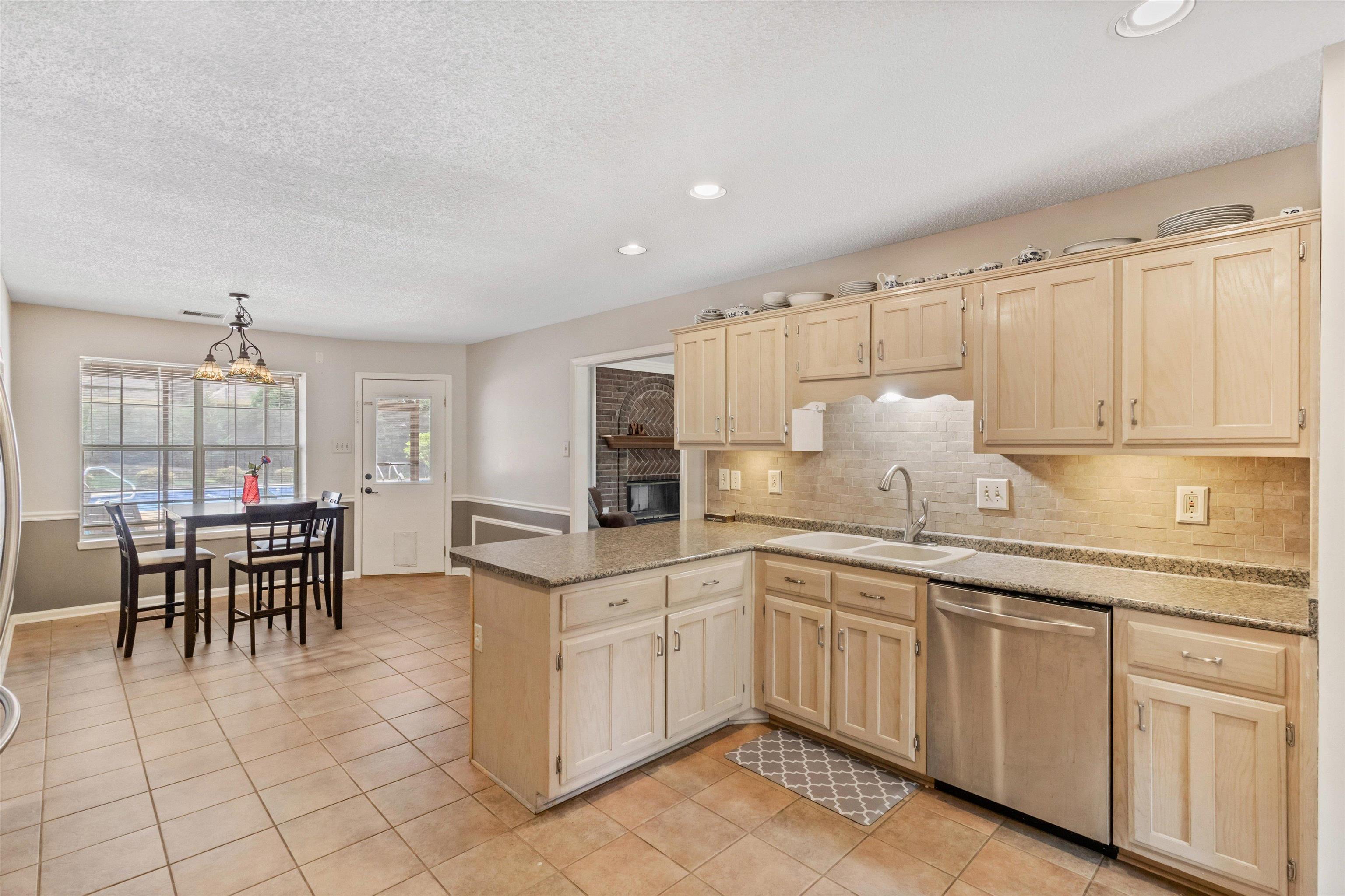 8821 Bazemore Road Memphis, TN 38018 - Photo 25 of 26 Kitchen with light brown cabinets, tasteful backsplash, stainless steel dishwasher, a peninsula, and light tile patterned floors