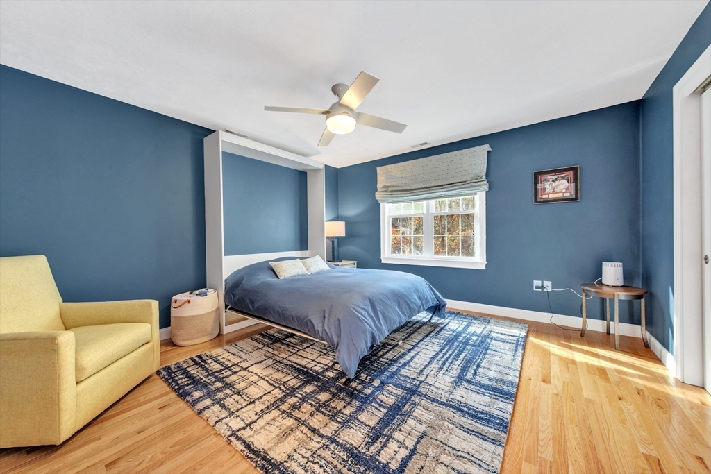 24 River Point Drive, Unit 6 Ipswich, MA 01938 - Photo 21 of 27 a spacious bedroom with a bed a couch and a chandelier