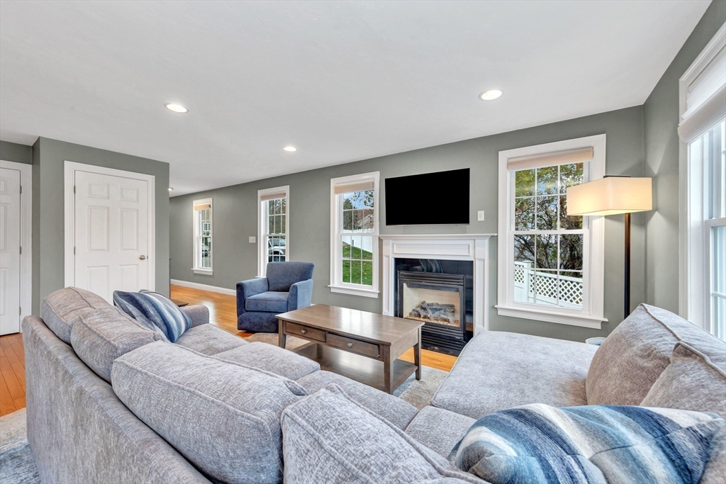 24 River Point Drive, Unit 6 Ipswich, MA 01938 - Photo 6 of 27 a living room with furniture a fireplace and a flat screen tv