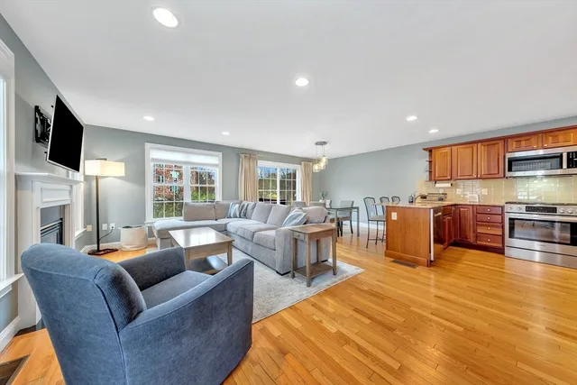 a living room with furniture kitchen view and a flat screen tv