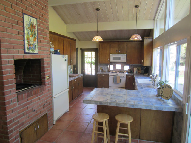419 Poppy Hill Road Watsonville, CA 95076 - Photo 12 of 25 a kitchen with stainless steel appliances wooden floor dining table and chairs