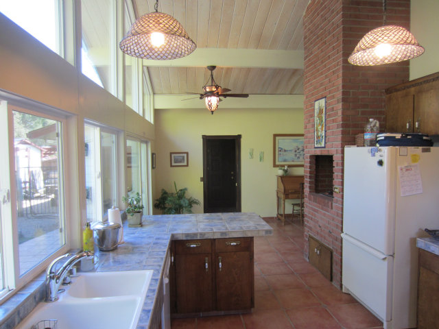 419 Poppy Hill Road Watsonville, CA 95076 - Photo 13 of 25 a kitchen with stainless steel appliances granite countertop a refrigerator a oven a sink and a dining table with wooden floor