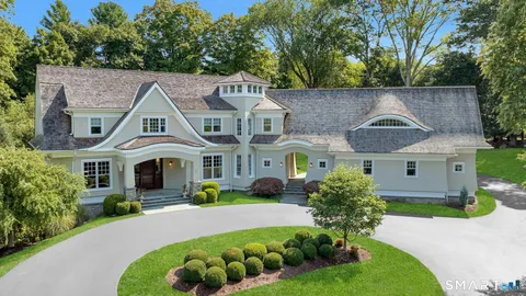 a front view of a house with a yard and potted plants