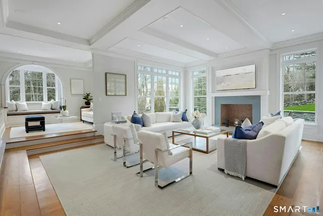 a living room with fireplace furniture and a large window