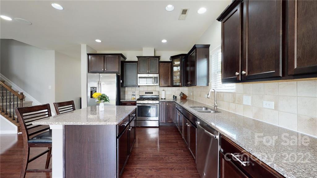 1549 Spring Blossom Trail Fort Mill, SC 29708 - Photo 20 of 45 a kitchen with stainless steel appliances granite countertop a sink stove and refrigerator
