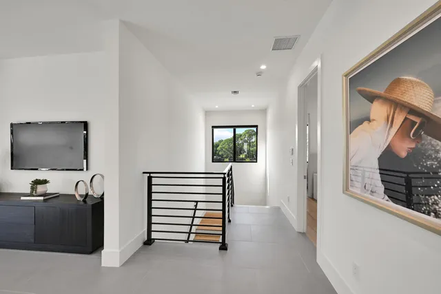 a bedroom with a bed and a flat tv screen on dresser