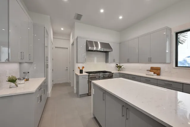 a large white kitchen with sink and cabinets