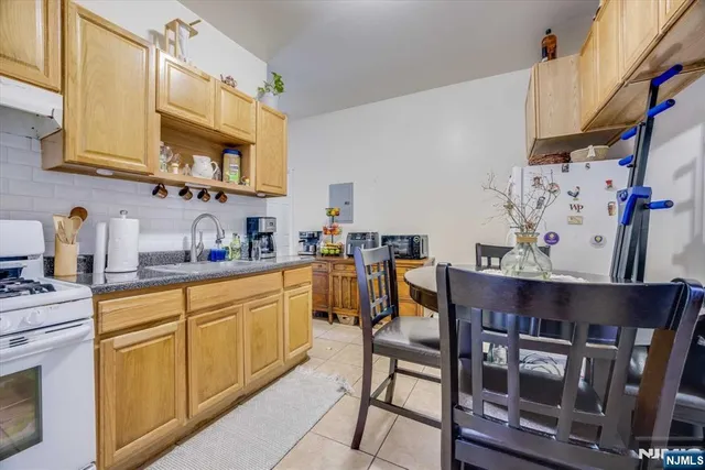 a kitchen with stainless steel appliances granite countertop a table chairs in it and wooden floors