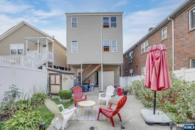 a view of house with a backyard and furniture