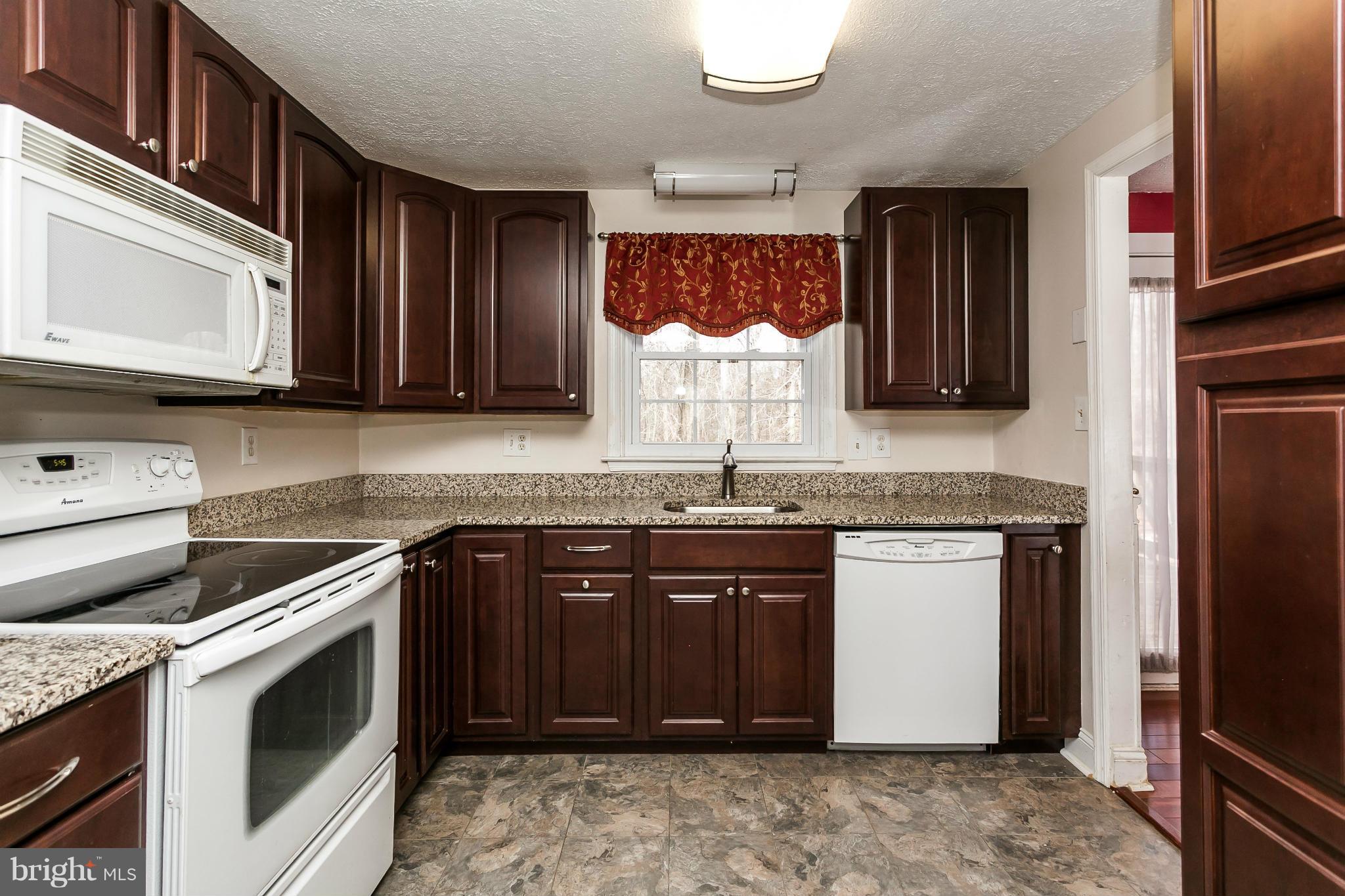 4804 Variation Road Baltimore, MD 21236 - Photo 11 of 27 a kitchen with stainless steel appliances granite countertop a stove a sink and a microwave