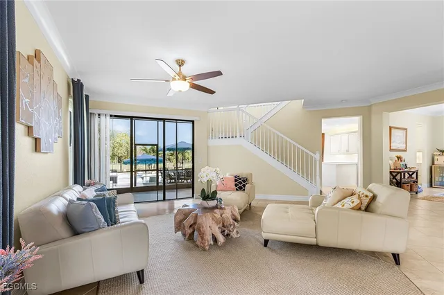 a living room with furniture and a large window with balcony view