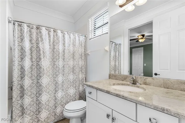 an empty room with wooden floor chandelier fan and windows