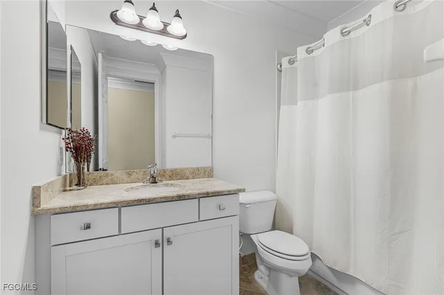 a view of a room with a ceiling fan and a carpet