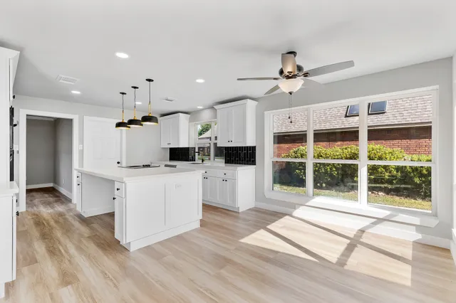 a kitchen with stainless steel appliances kitchen island granite countertop a stove a sink and a refrigerator