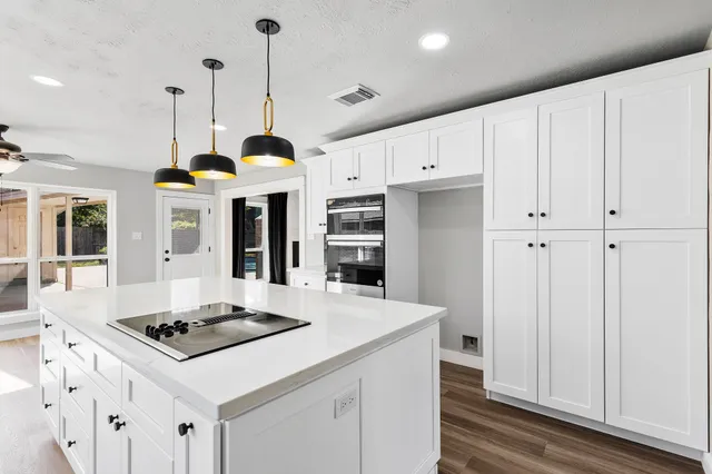 a kitchen with stainless steel appliances a stove a sink dishwasher and a refrigerator with wooden floor