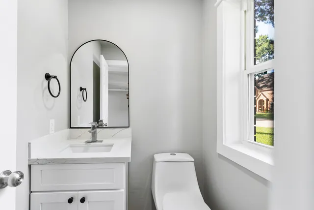 a bathroom with a toilet sink and mirror