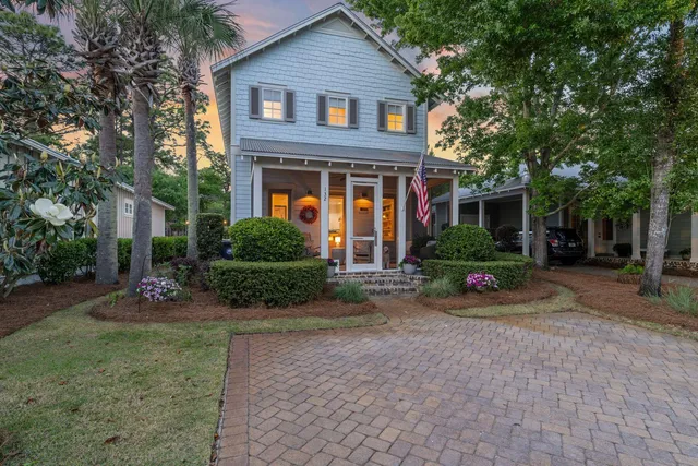 a front view of a house with a yard and potted plants
