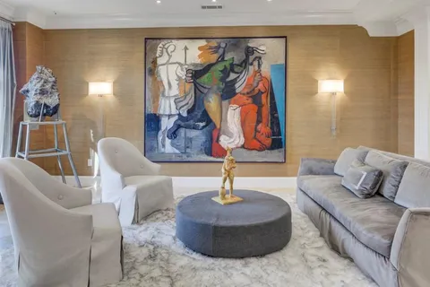 a living room with furniture and painting on the wall