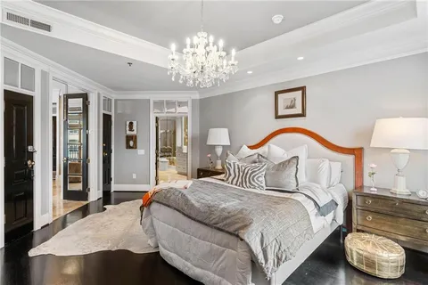 a bedroom with bed and a chandelier