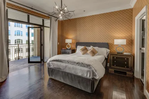 a bedroom with a large bed and a chandelier