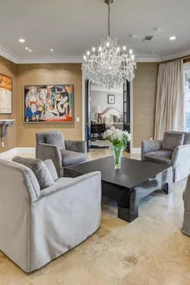 a living room with furniture a chandelier and a large mirror