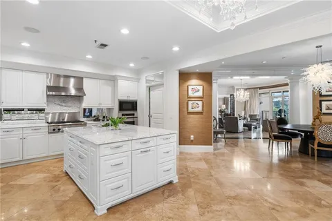 a kitchen with stainless steel appliances kitchen island granite countertop a refrigerator and cabinets