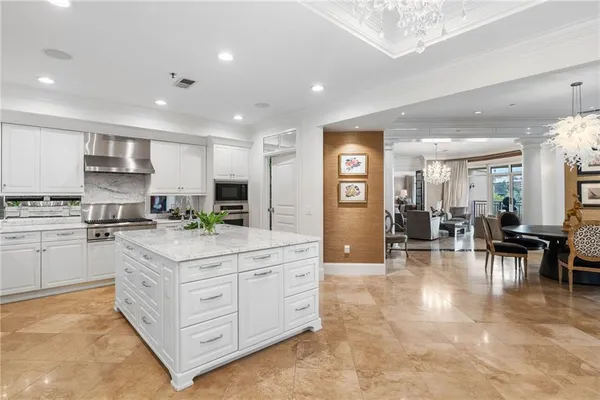 a kitchen with stainless steel appliances kitchen island granite countertop a refrigerator and cabinets