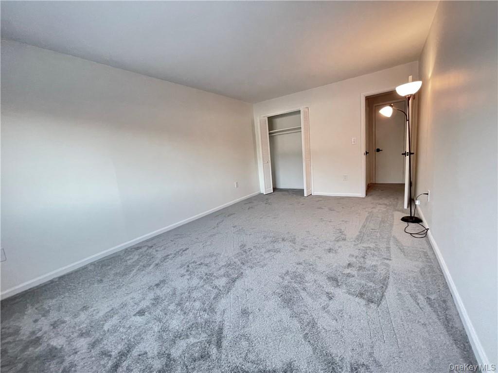27 Tanager Road, Unit 2702 Monroe, NY 10950 - Photo 14 of 17 Spacious room featuring gray wall-to-wall carpeting, white baseboards, and a built-in closet with a clothes rod