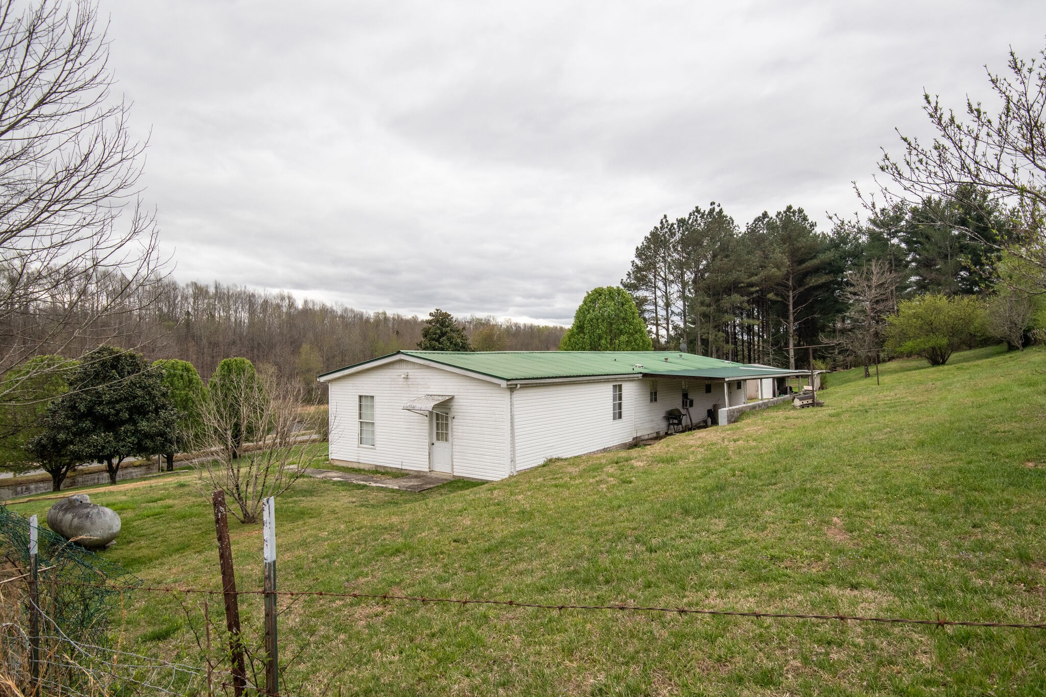 693 Littrell Road Loretto, TN 38469 - Photo 45 of 57 a white house with a big yard and large trees