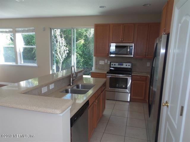 124 Bay Bridge Drive St. Augustine, FL 32080 - Photo 4 of 19 a kitchen with granite countertop a refrigerator and a sink
