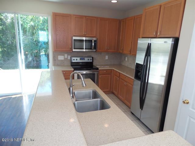 124 Bay Bridge Drive St. Augustine, FL 32080 - Photo 6 of 19 a kitchen with stainless steel appliances a refrigerator a stove a sink a washer dryer and white cabinets