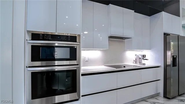 a kitchen with stainless steel appliances a stove microwave and sink