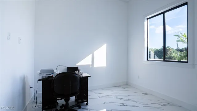 a view of a workspace with furniture and a window