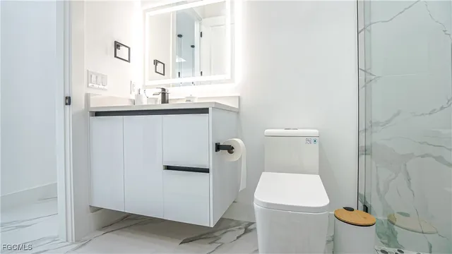a bathroom with a granite countertop toilet and a sink