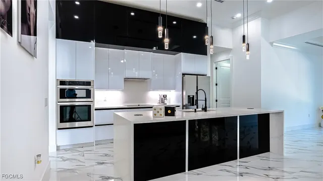 a kitchen with stainless steel appliances kitchen island granite countertop a sink a stove and cabinets