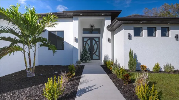 a large kitchen with stainless steel appliances kitchen island granite countertop a table chairs and a refrigerator