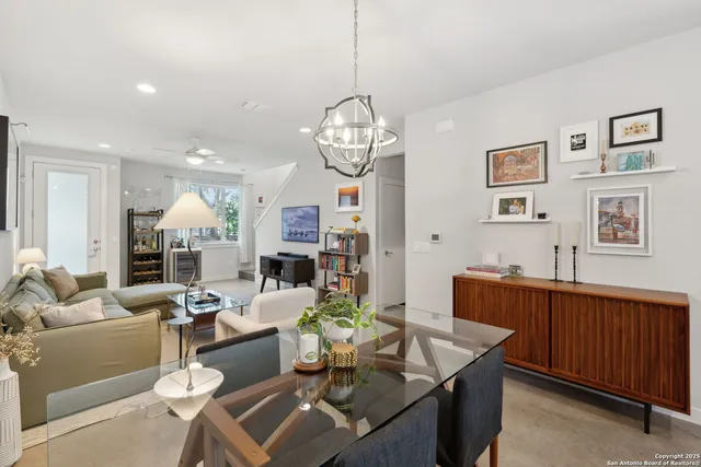 a living room with furniture a dining table and a chandelier