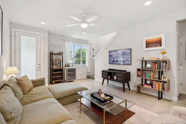 a living room with furniture a bookshelf and a window